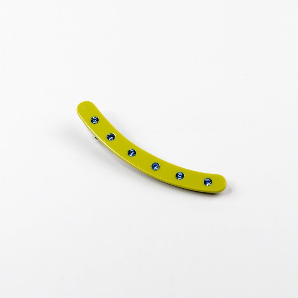 Yellow curved hair clip with blue rhinestones on a white background