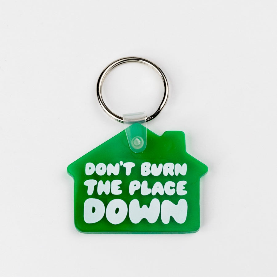 Green house-shaped keychain with 'Don't Burn The Place Down' text on a white background