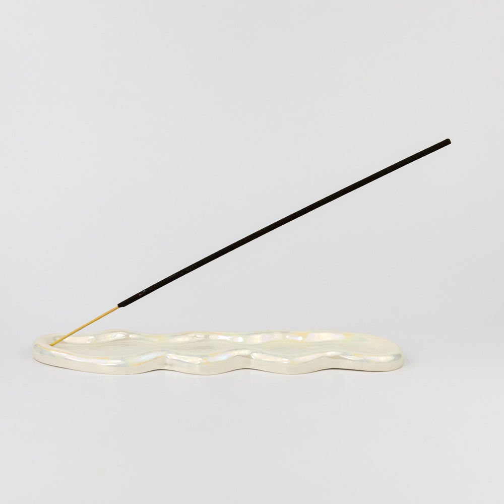 Incense stick on a white base with a gray background