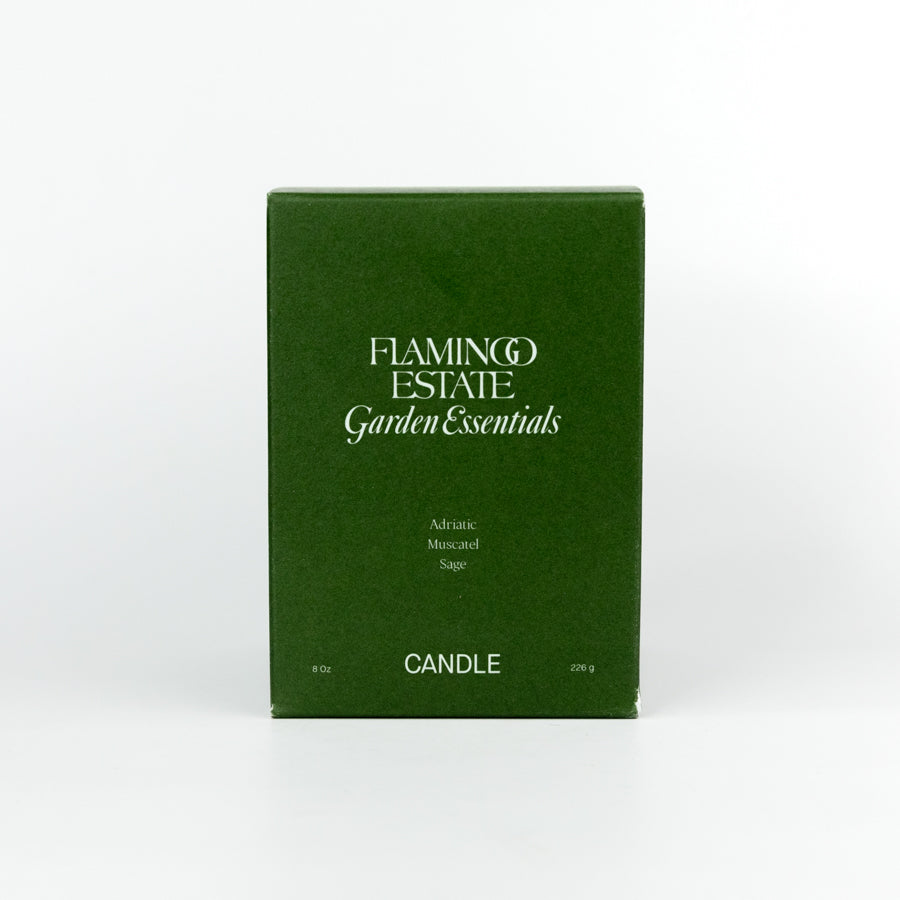 Green box of Flamingo Estate Garden Essentials candle on a white background