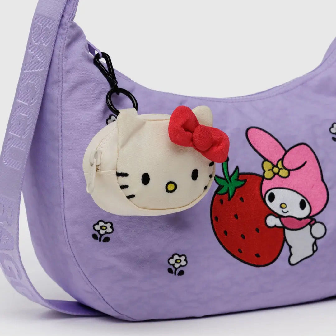 Purple handbag with Sanrio characters including a Hello Kitty head shaped zipper pouch bag charm hanging from the bag strap