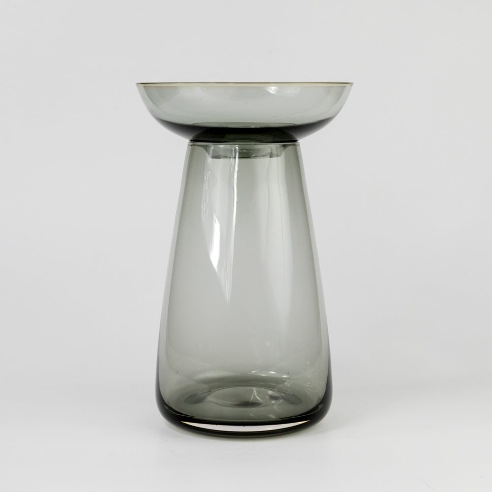 Clear glass vase with a wide base and narrow top on a white background