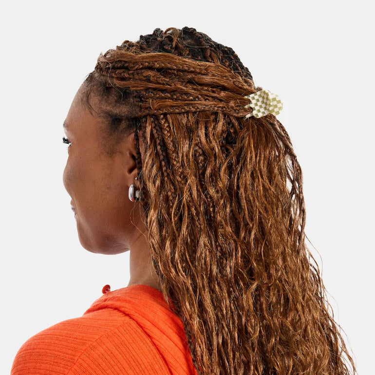 Woman with braided hair wearing an orange top on a white background
