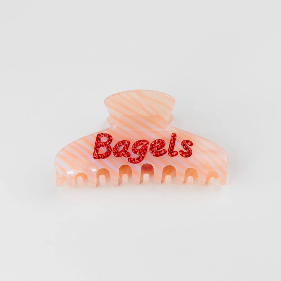 Pink hair clip with 'Bagels' text on a white background