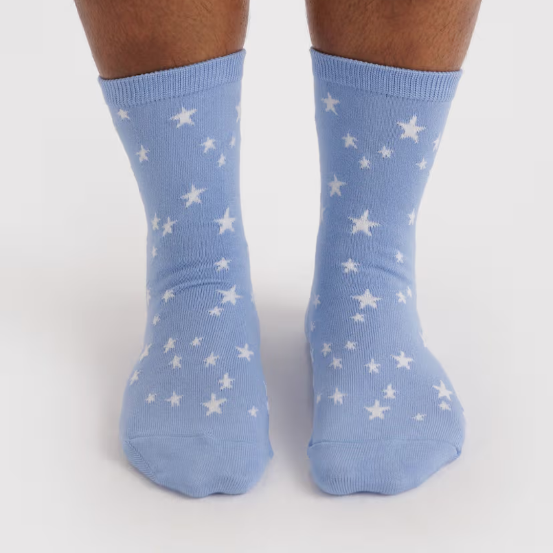 Light blue socks with white star patterns on a light gray background