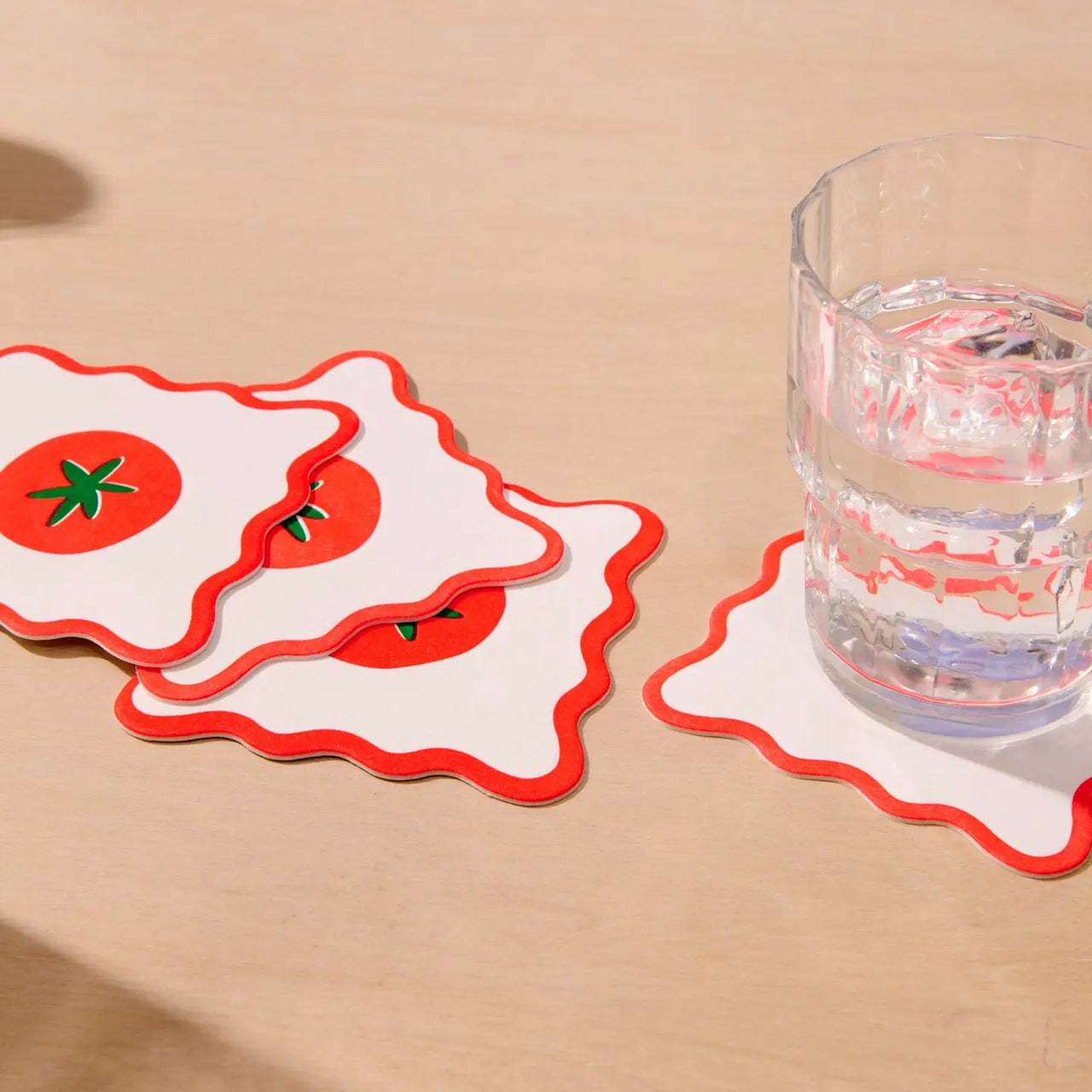 Pack of coasters with a tomato design on a white background