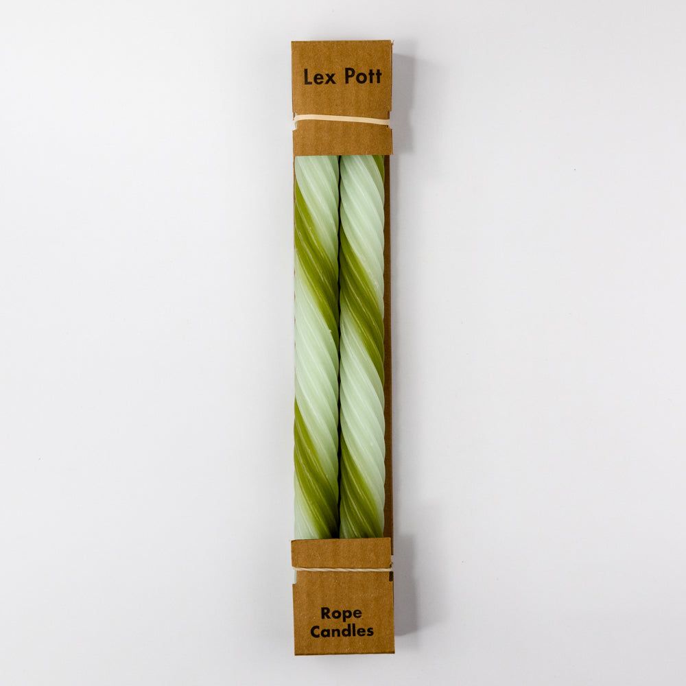 Two green and white striped candles on a light gray background