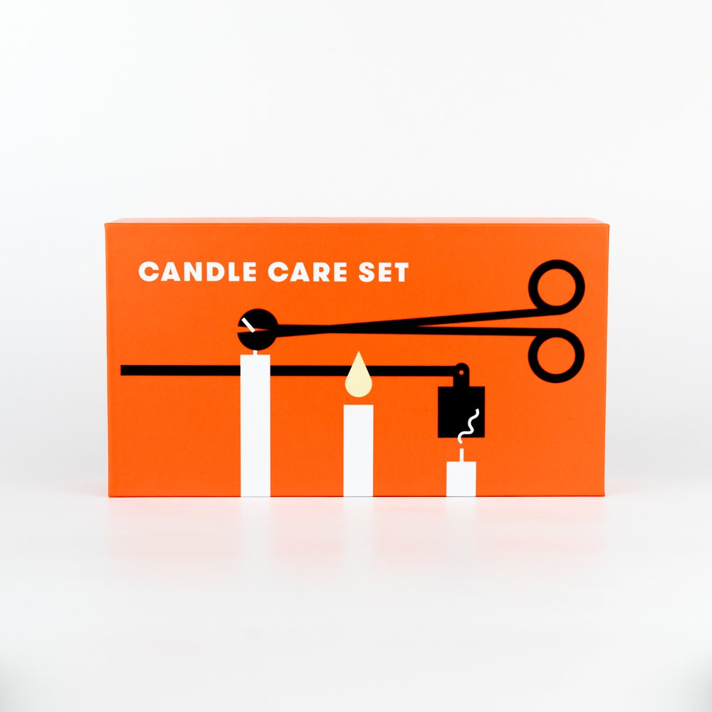 Candle care set packaging with an orange background and black illustrations of a candle and wick trimmer.