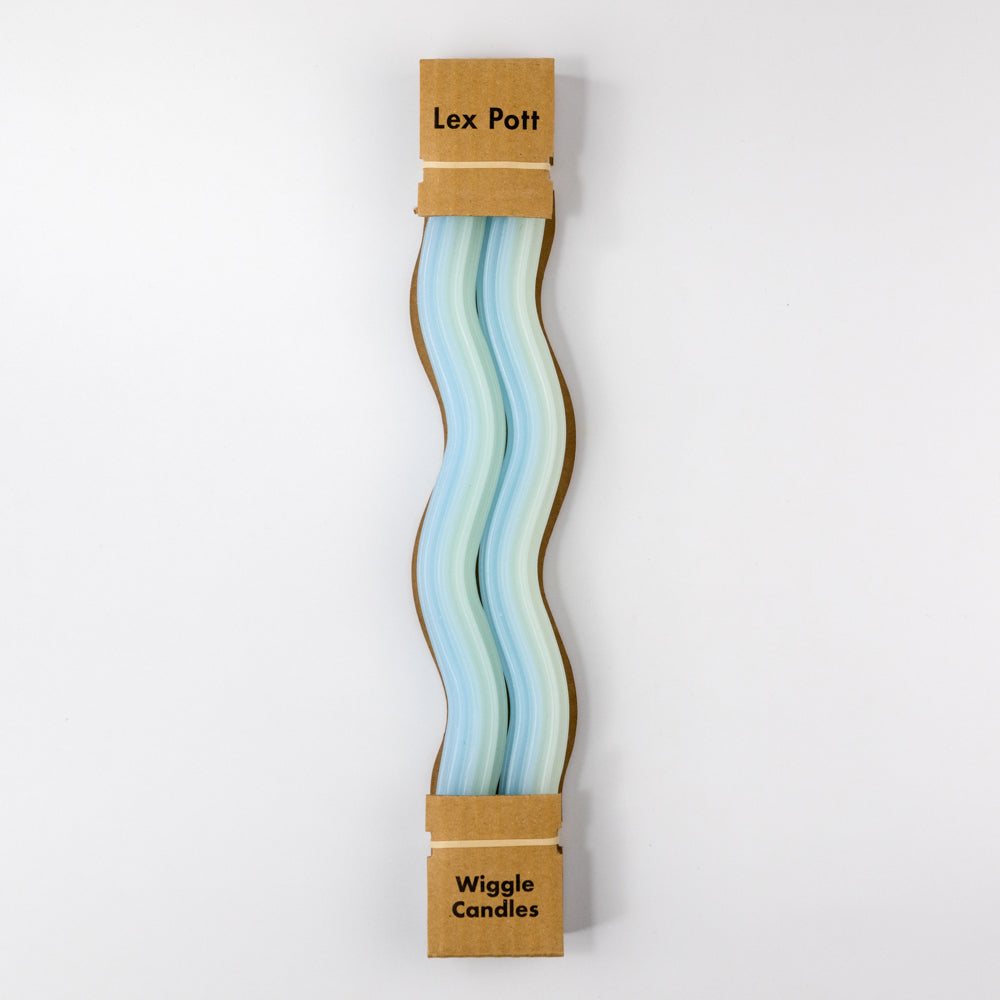 Two green and blue striped candles on a white background