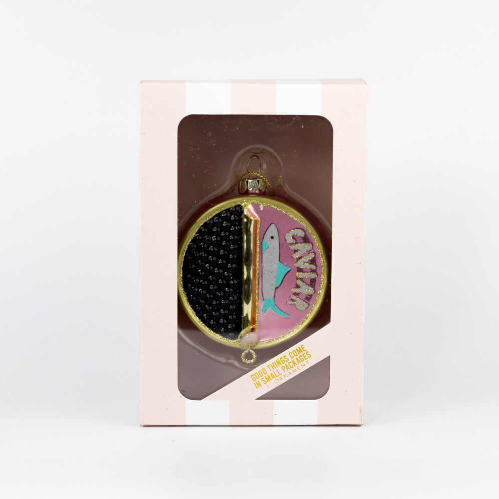 Decorative Christmas ornament shaped as a partially open can of caviar hanging on a tree branch.