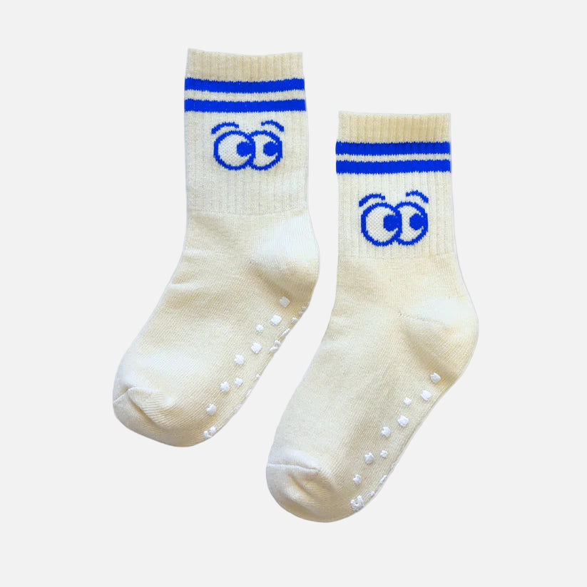 Pair of beige socks with blue accents and white dots on a light gray background