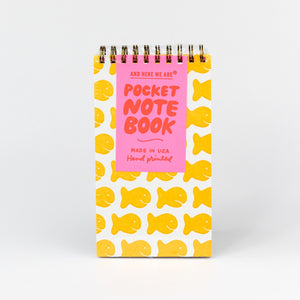 Pocket notebook with yellow fish pattern and pink label on a white background