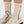 Beige loafers with pink bowdesign socks on a white background