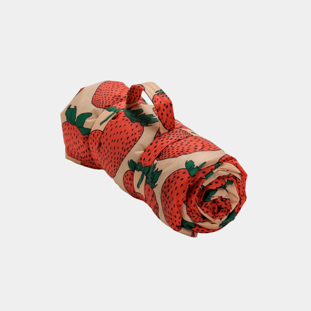 Rolled-up fabric with strawberry pattern on a light gray background