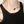 Necklace with a black pendant worn by a person in a black tank top against a neutral background