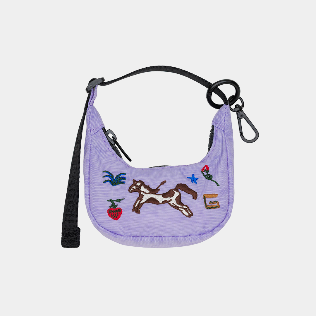 Purple bag charm with embroidered designs on a light gray background