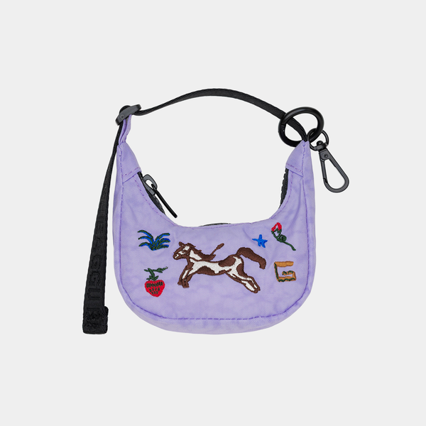 Purple bag charm with embroidered designs on a light gray background