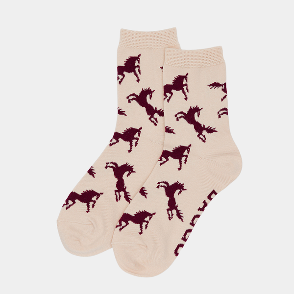 Beige socks with red horse patterns on a light beige background