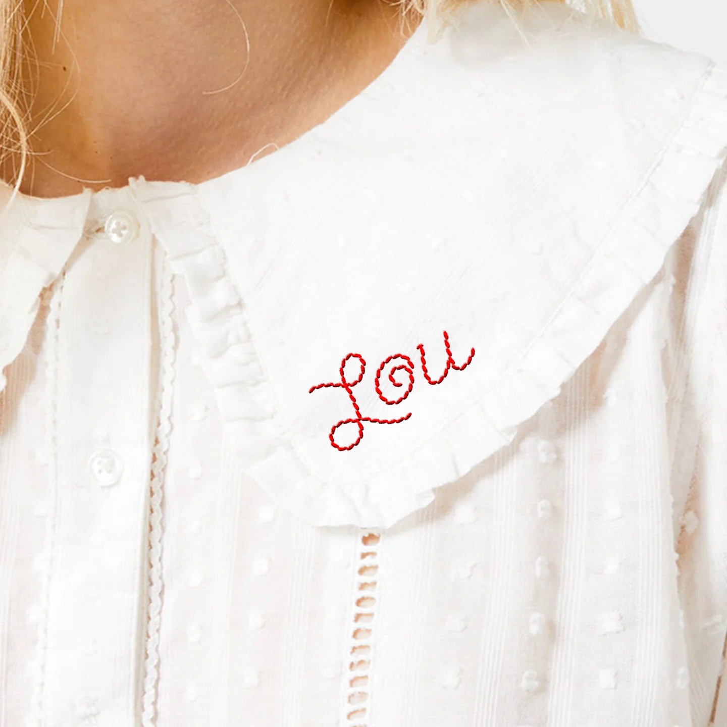 White blouse with 'Lou' embroidered on it