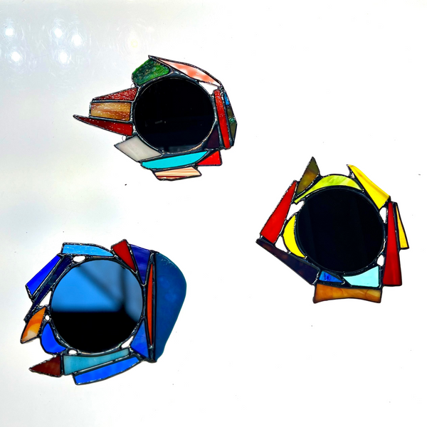 Three colorful geometric stained-glass mirrors on a white background