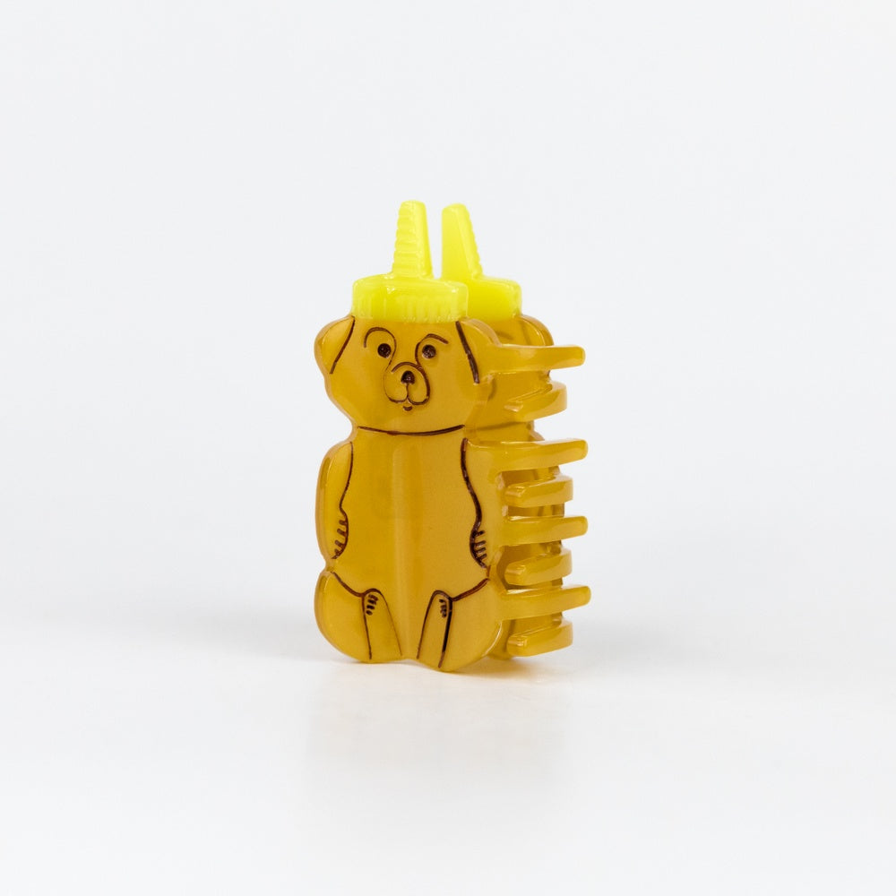 Yellow bear-shaped condiment bottle with two yellow nozzles on a white background