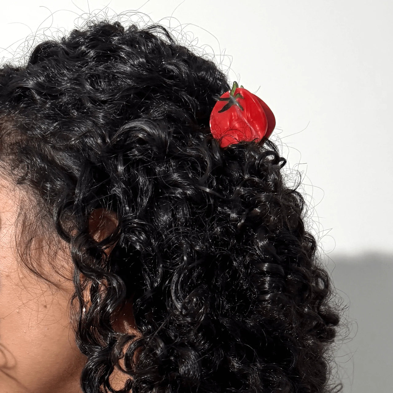 Red tomato-shaped hair claw on a white background
