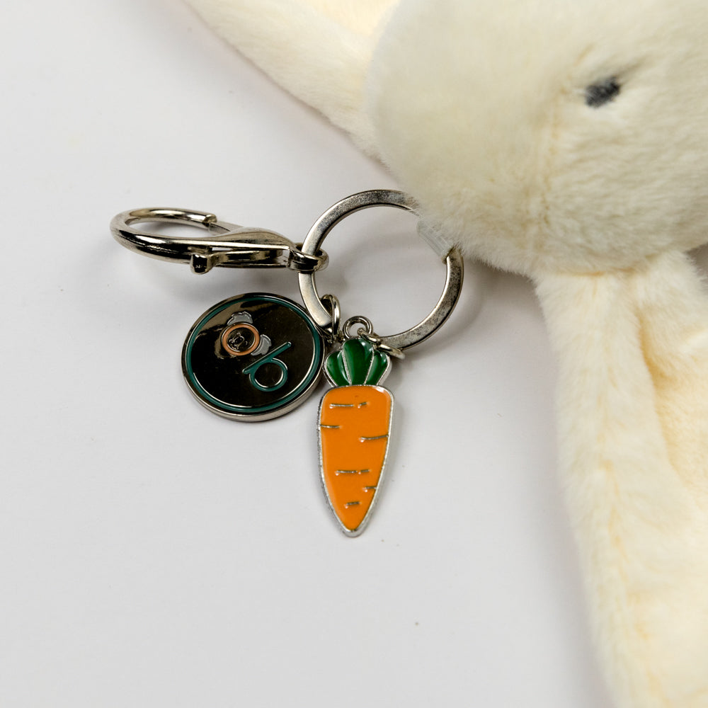 White plush bunny keychain with carrot charm on a white background