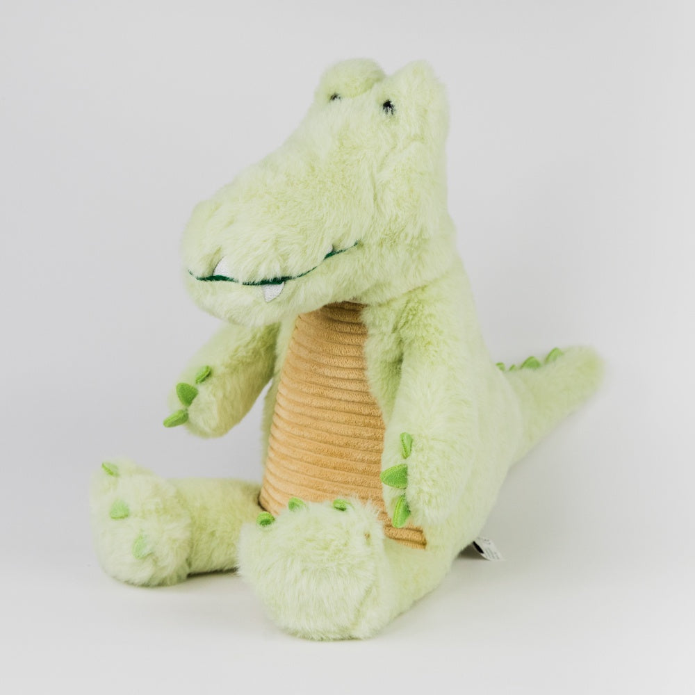Green plush toy alligator with a brown belly on a white background