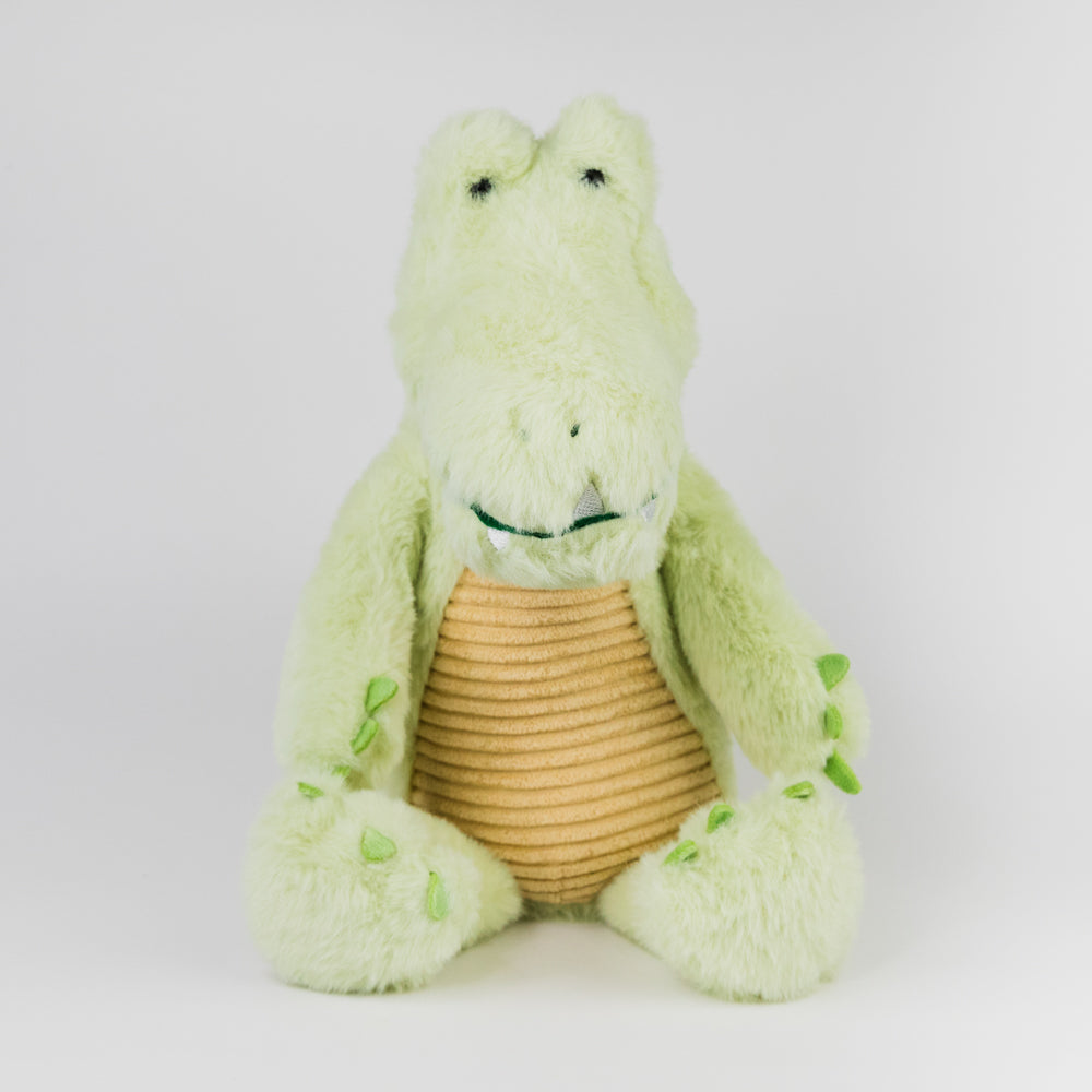 Green plush toy alligator with a brown belly on a white background
