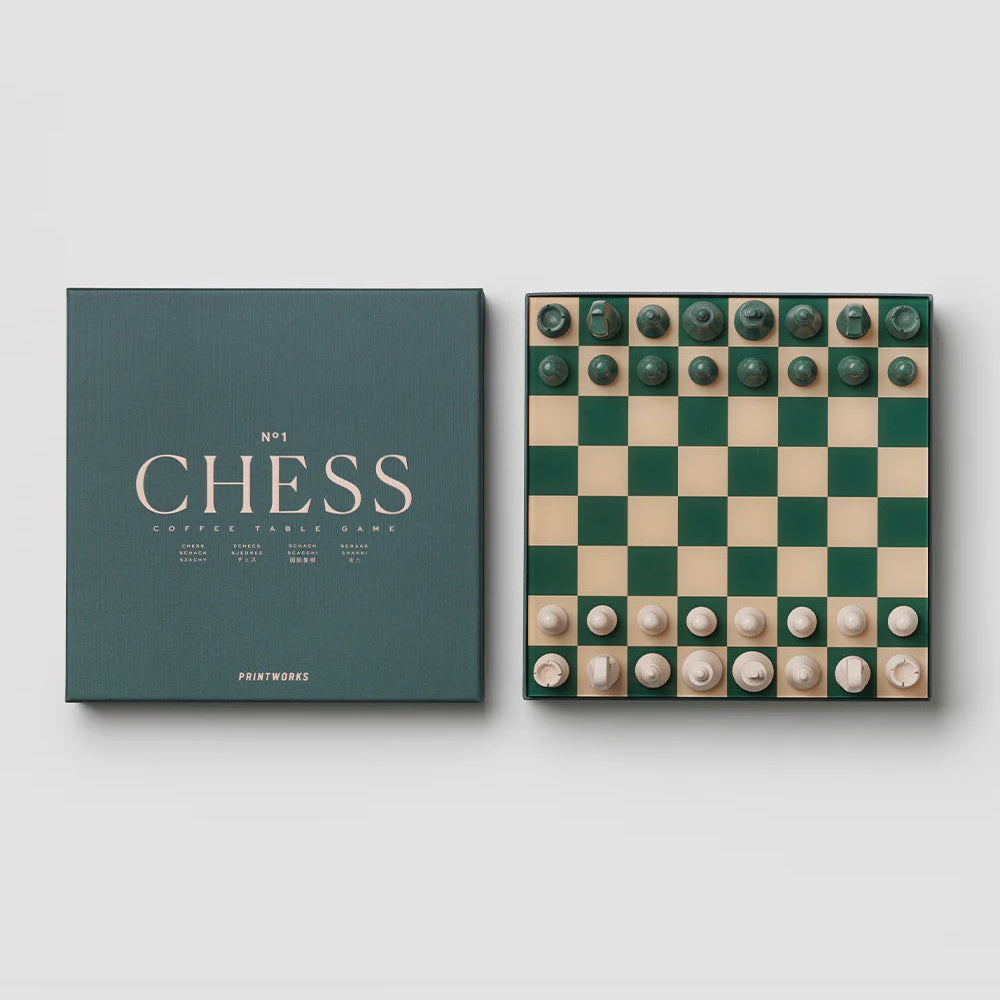 Chess set with green and beige pieces and a matching box on a white background