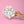Hand holding two sheets of colorful unicorn-themed tattoos against a pink background