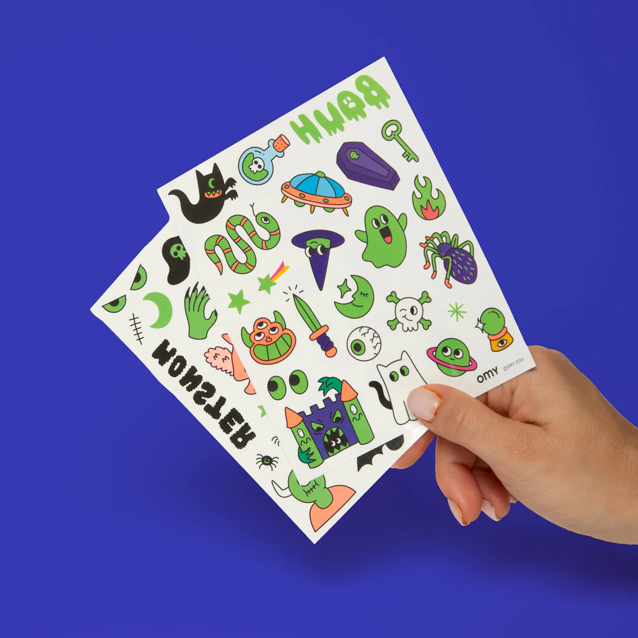 Green packaging of OMY tattoos with cartoon designs on a white background