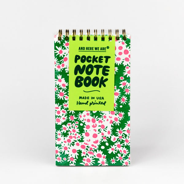Pocket notebook with floral pattern and green text on a white background