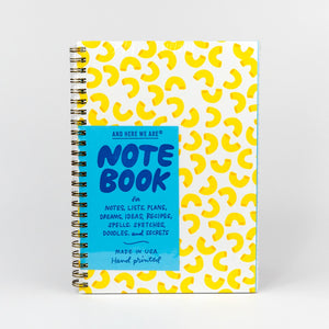 Notebook with yellow pattern and blue label on a white background