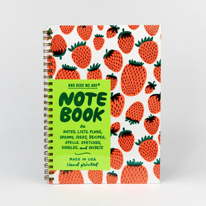 Notebook with strawberry pattern and green label on a white background