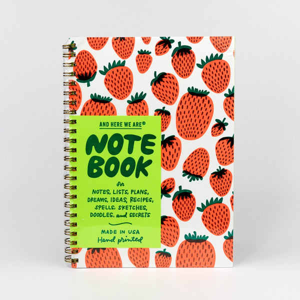 Notebook with strawberry pattern and green label on a white background