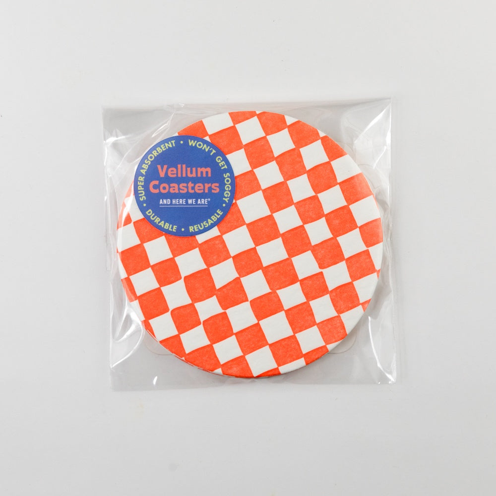 Packaged round coaster with orange and white checkered pattern on a light gray background