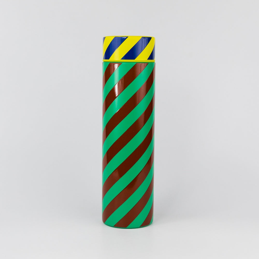 Cylindrical object with green and brown striped pattern on a white background