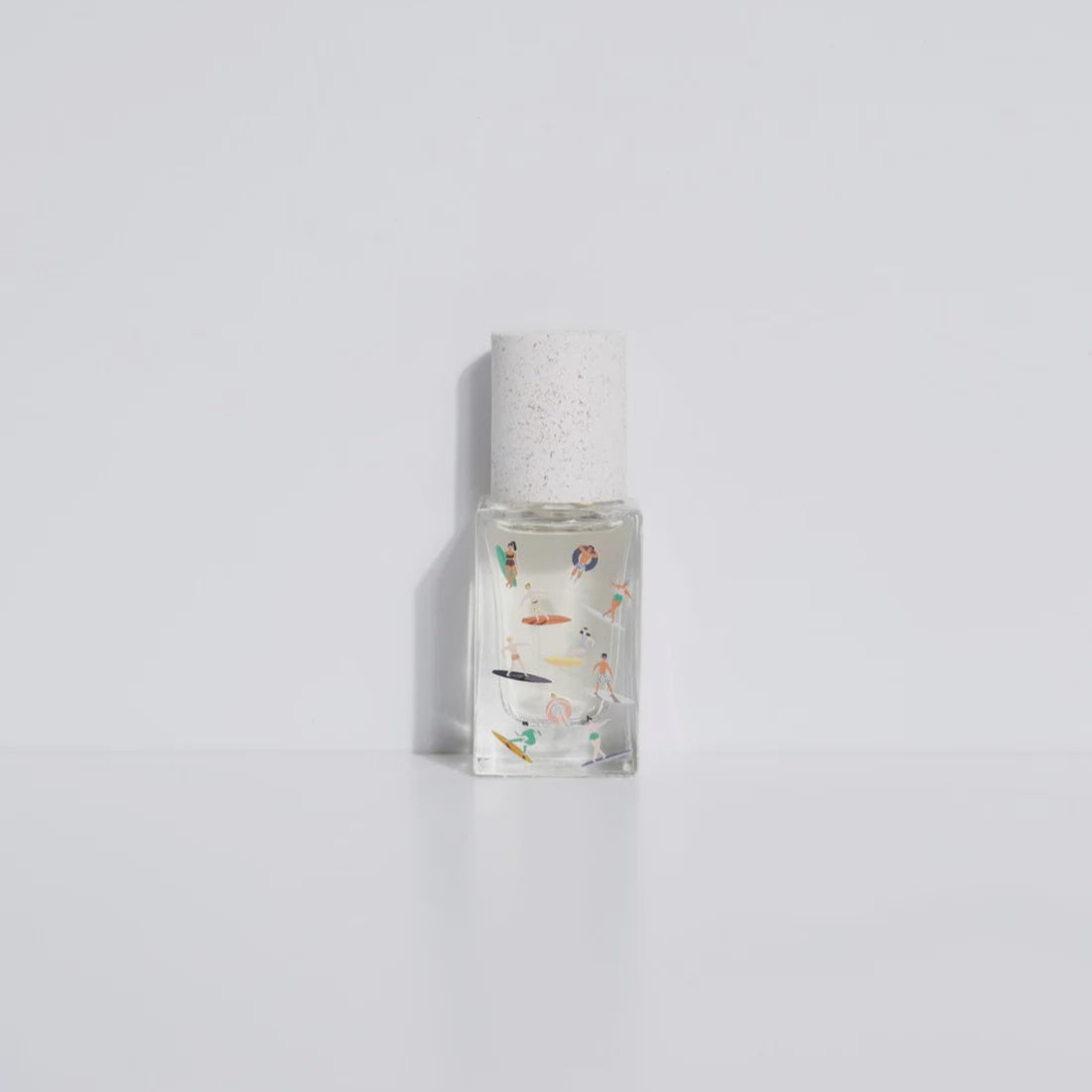 Clear perfume bottle with colorful design on a light gray background