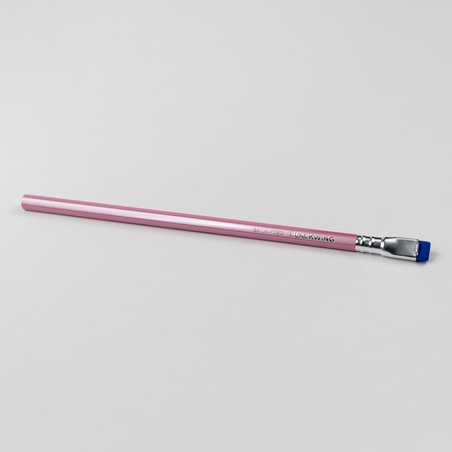 Pink pencil with a blue ferrule on a light gray background
