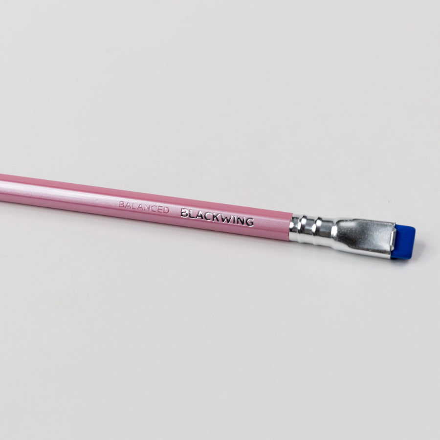 Pink Blackwing pencil with blue eraser on a light gray background