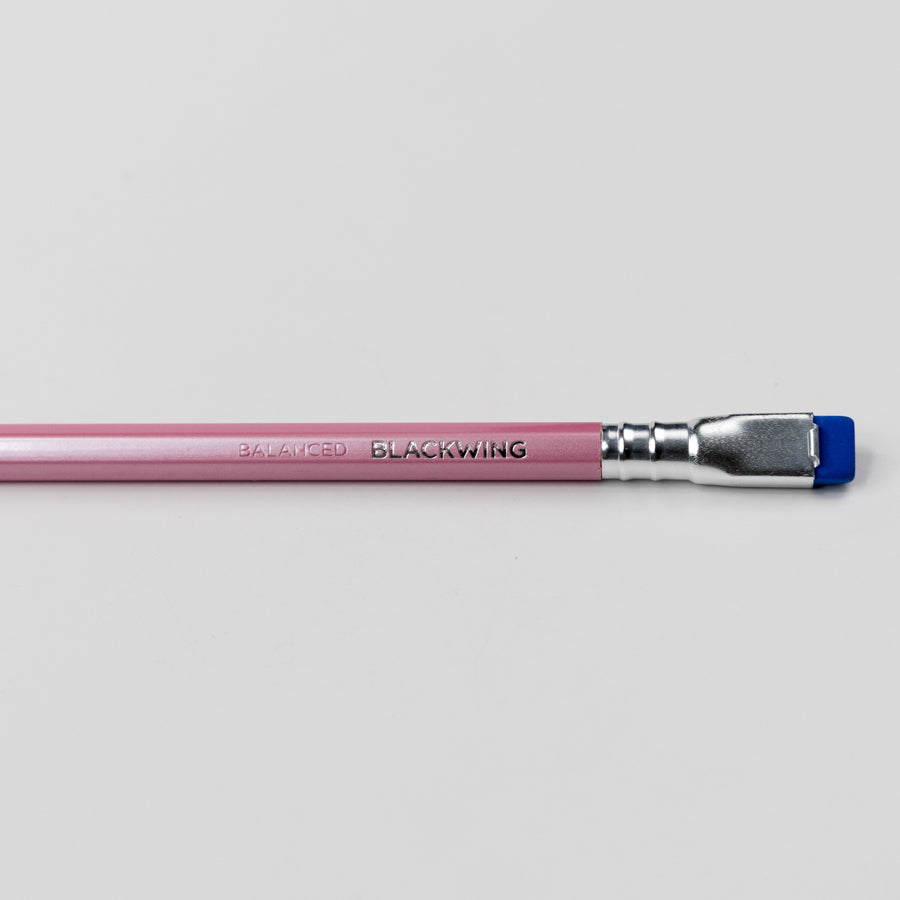 Pink pencil with blue eraser on a light gray background