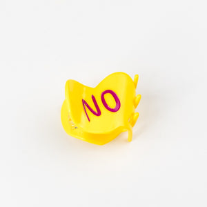 Yellow plastic clip with 'NO' on a white background