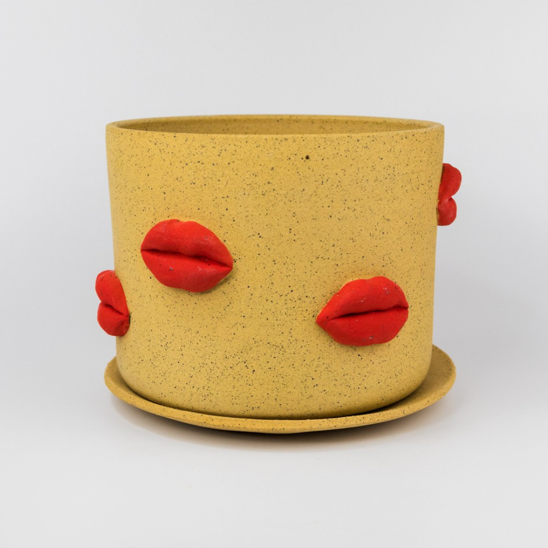 Yellow planter with red lips on a white background