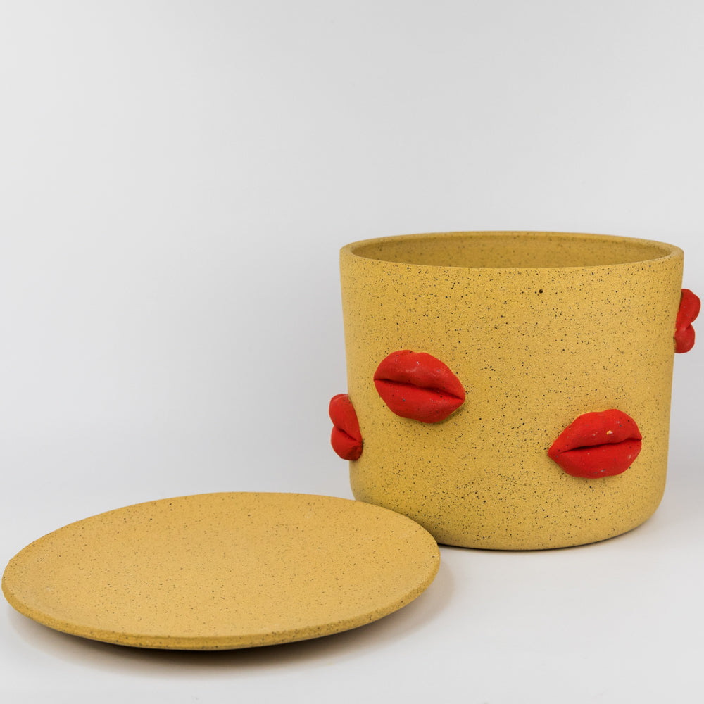 Yellow planter with red lips on a white background