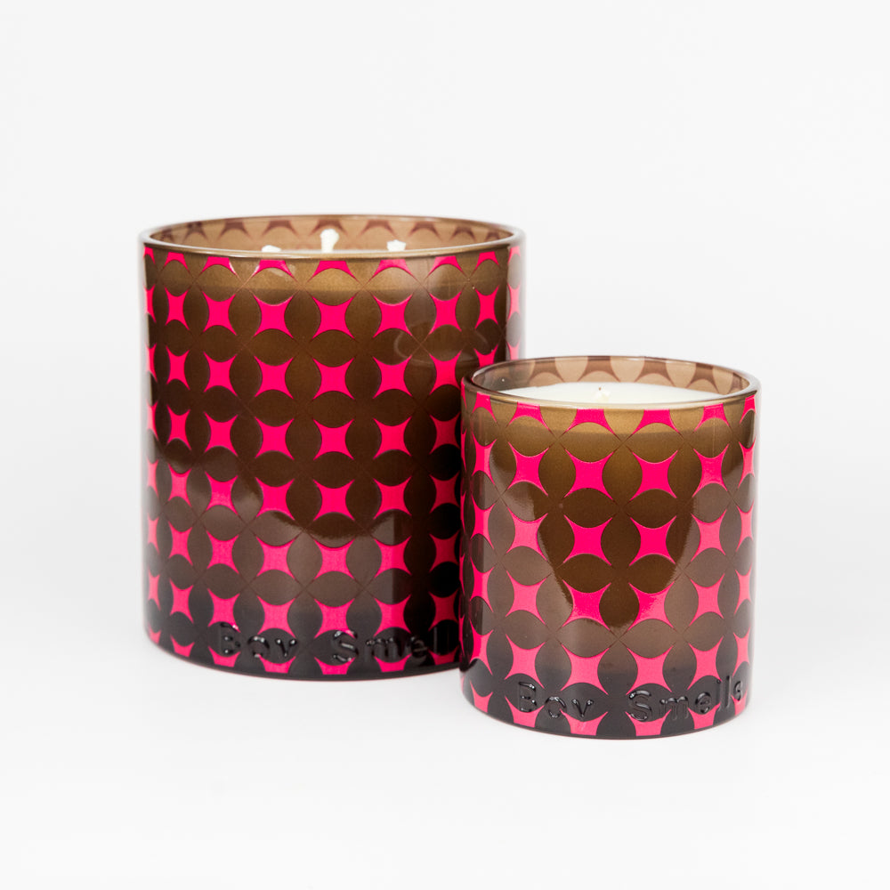 Two candles with pink and brown patterned lids on a white background