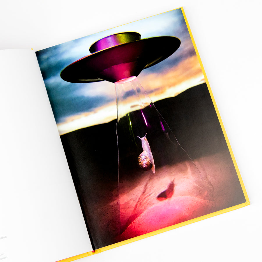 Magazine cover with a UFO and snail alien design on a colorful background