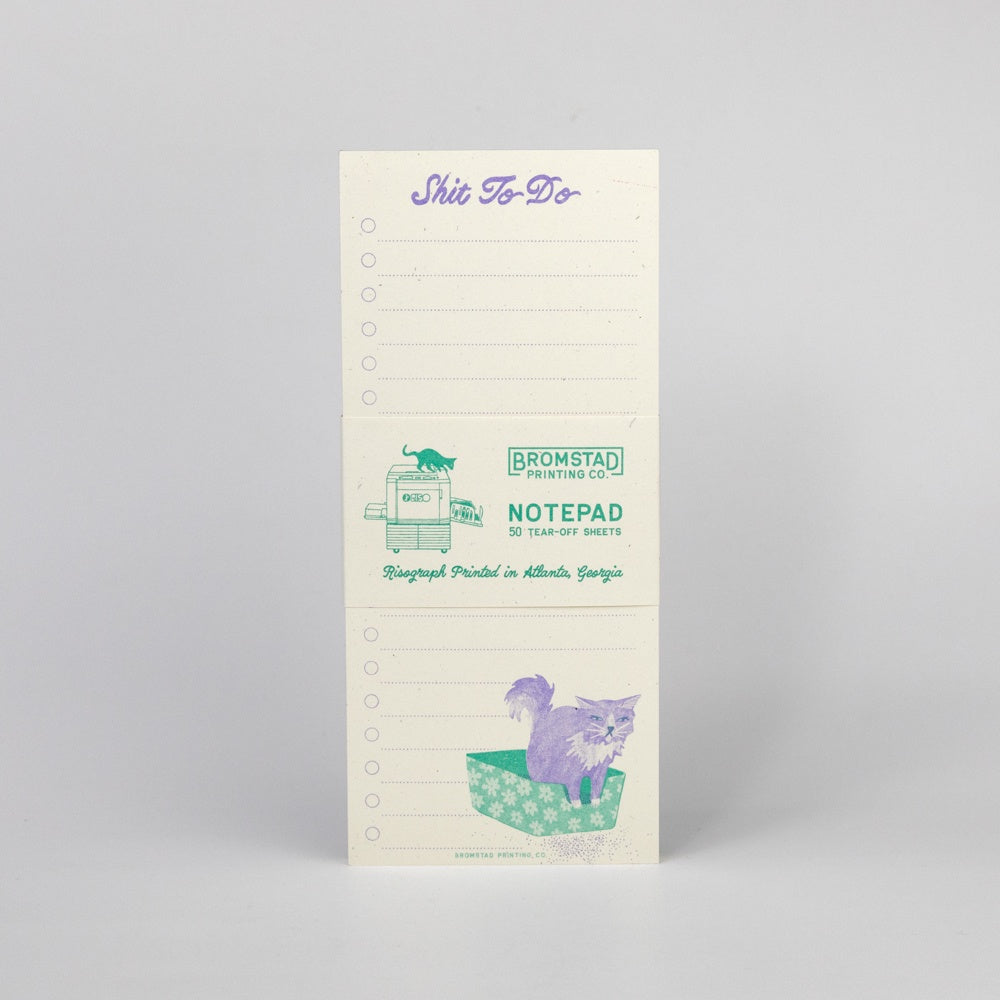 Notepad with cat illustration and text on a gray background