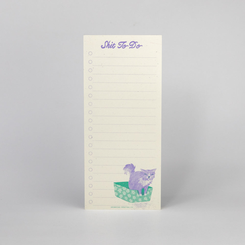 Notepad with cat illustration and text on a gray background