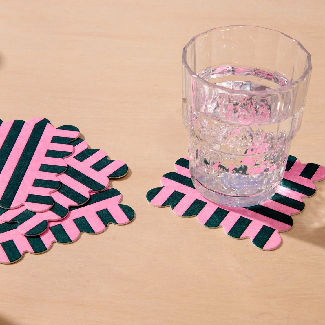 Pack of pink and dark green striped coasters with a Vellum Coasters label on a white background